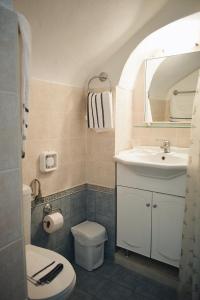 uma casa de banho com um lavatório, um WC e um espelho. em Yi artistry 1-bedroom medieval holiday house em Kalamoti