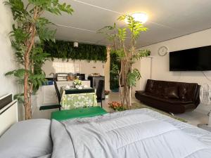 暖武里的住宿－C9 Popula Condo by Prathomlerk，一间卧室配有床和沙发,树木茂密