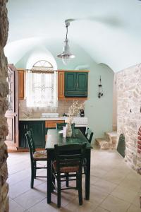 uma cozinha com mesa e cadeiras num quarto em Yi artistry 1-bedroom medieval holiday house em Kalamoti