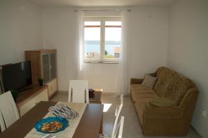 a living room with a couch and a table at Apartments Brko in Maslenica