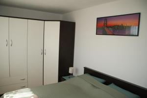 1 dormitorio con 1 cama y una foto en la pared en Apartments Brko, en Maslenica