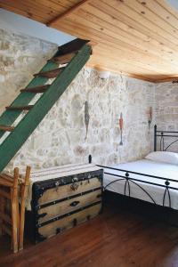 a bedroom with a bed and a stone wall at Yi artistry 1-bedroom medieval holiday house in Kalamoti