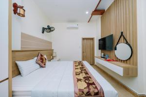 a bedroom with a large bed and a television at My Ngoc Hotel in Cat Ba