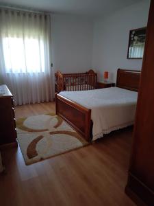 1 dormitorio con cama y alfombra en el suelo de madera en Casa do Campo, en Seia