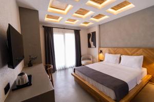 sypialnia z dużym łóżkiem i dużym oknem w obiekcie Leone Cunda Edition Otel w mieście Ayvalık