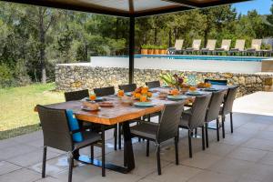 a wooden table and chairs on a patio at Villa Can Rafalet in Sant Josep de sa Talaia
