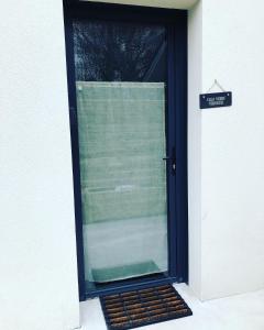uma porta preta com uma janela com um sinal em Gîte Cala Verde Terrasse, à 4km de la première plage em Audenge