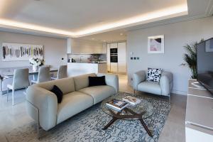 uma sala de estar com um sofá e uma mesa em Parc du Cap Luxury Apartment em Antibes