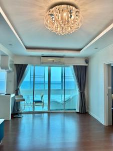a living room with a chandelier and ocean views at บ้านชายทะเล ที่พักติดทะเล ระยอง หาดแสงจันทร์ in Rayong