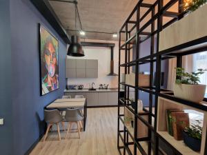 a kitchen and a living room with a table and chairs at Apart Hotel LOFT in Almaty