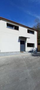 a white building with a parking lot in front of it at Casa pipete in Siero