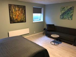 - un salon avec un lit et un canapé dans l'établissement Brønks Bed and Breakfast, à Langeskov