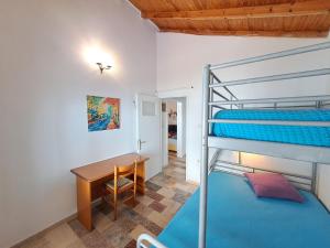 a bedroom with a bunk bed and a table and a desk at Beach House Kotrona in Achladi