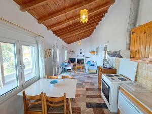 a kitchen and living room with a table and a stove at Beach House Kotrona in Achladi