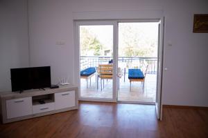 a living room with a tv and a sliding glass door at Villa Alvin in Kosor