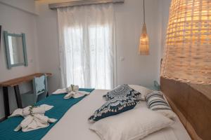 - une chambre avec 2 lits avec des oreillers et une fenêtre dans l'établissement Nausika Rustic Cottage, à Paleokastritsa