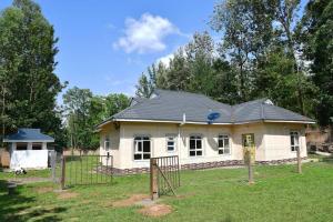 une petite maison avec une clôture devant elle dans l'établissement Greenstar suites, à Bungoma