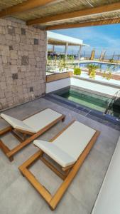 patio z 2 leżakami i basenem w obiekcie Leone Cunda Edition Otel w mieście Ayvalık