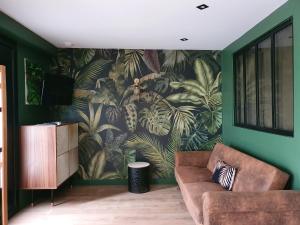 uma sala de estar com um sofá e um mural de parede em Jungle em Mios