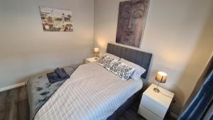 een kleine slaapkamer met een bed en 2 lampen bij Rutland Street Townhouse Belfast in Belfast