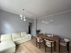 a living room with a white couch and a table at Apartament Olivia Business Suite in Gdańsk