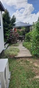 a backyard with a picnic table and a wooden walkway at CHURCHILL COTTAGE- 94 Churchill St Maryborough QLD in Maryborough
