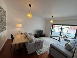 a living room with a couch and a table at Conforto, espaço e localização in Ribeira Grande
