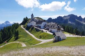 um edifício sobre uma colina com uma igreja sobre ele em Rododendro 10 em Tarvisio