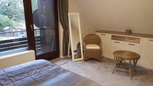 ein Schlafzimmer mit einem Bett, einem Stuhl und einem Fenster in der Unterkunft Küstenbude Nachtigall in Grömitz