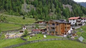 a resort in the mountains with a green field at Bio & Reiterhof der Veitenhof in Umhausen