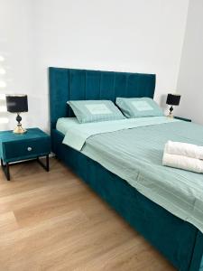 1 dormitorio con 1 cama azul y 2 mesitas de noche en panoramic apartment EdenTower, en Bat Yam
