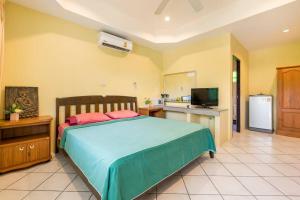 1 dormitorio con 1 cama grande y cocina en Baan Coconut en Bang Tao Beach