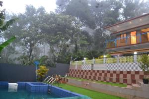 a house with a swimming pool in front of a house at Arabian Nights Munnar,Family Villa with Pool in Munnar