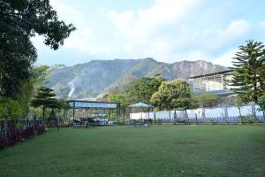 um parque com mesas e cadeiras em frente a um edifício em Bharat Resorts em Dehradun