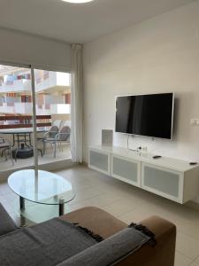 a living room with a couch and a tv at Apartamento en Playa Flamenca (residencial El Rincon) in Playas de Orihuela