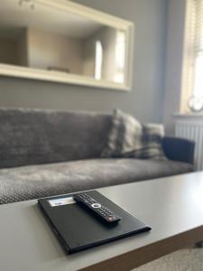 a remote control sitting on a table with a couch at Eclipse Apartment No 2 in Newmarket