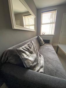 a couch with two pillows in a room with a mirror at Eclipse Apartment No 2 in Newmarket