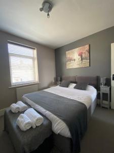 a bedroom with a large bed with towels on it at Eclipse Apartment No 2 in Newmarket