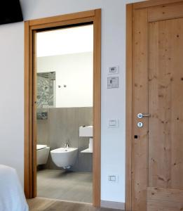 Łazienka z drewnianymi drzwiami i umywalką w obiekcie Casa Bortolin w mieście Valdobbiadene