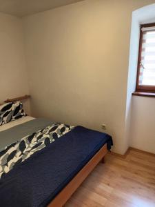 a bedroom with a bed and a window at Apartments Dorcic in Baška