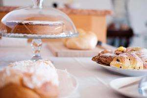 stół z dwoma talerzami wypieków i ciastem w obiekcie Casa Bortolin w mieście Valdobbiadene