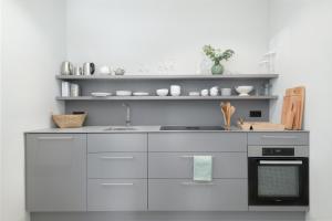 a kitchen with white cabinets and a sink at Exklusiv: Historisches Apartment mit Deckengewölbe in Munich