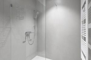 uma casa de banho com um chuveiro e uma porta de vidro em Exklusiv: Historisches Apartment mit Deckengewölbe em Munique