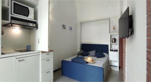 a small bedroom with a blue couch and a tv at La Romantique in Anacapri