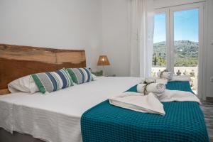 a bedroom with a large white bed with a window at Nausika Rustic Cottage in Paleokastritsa