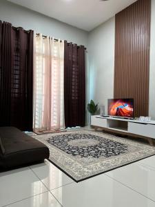 a living room with a television and a rug at Cassa Vistana Homestay Alor - Langgar near HSB in Alor Setar
