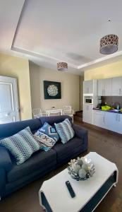 sala de estar con sofá azul y cocina en Vivienda Vacacional La Candelaria, en Los Llanos de Aridane
