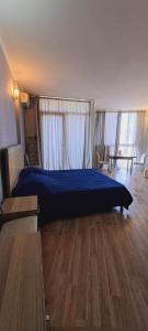 a bedroom with a blue bed in a room with wooden floors at Orbi Plaza Apartment in Batumi