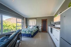 a bedroom with a bed and a large window at Gaia Hydro-Spa and Guest House in Cape Town
