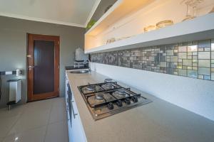 a kitchen with a stove top oven in a kitchen at Gaia Hydro-Spa and Guest House in Cape Town